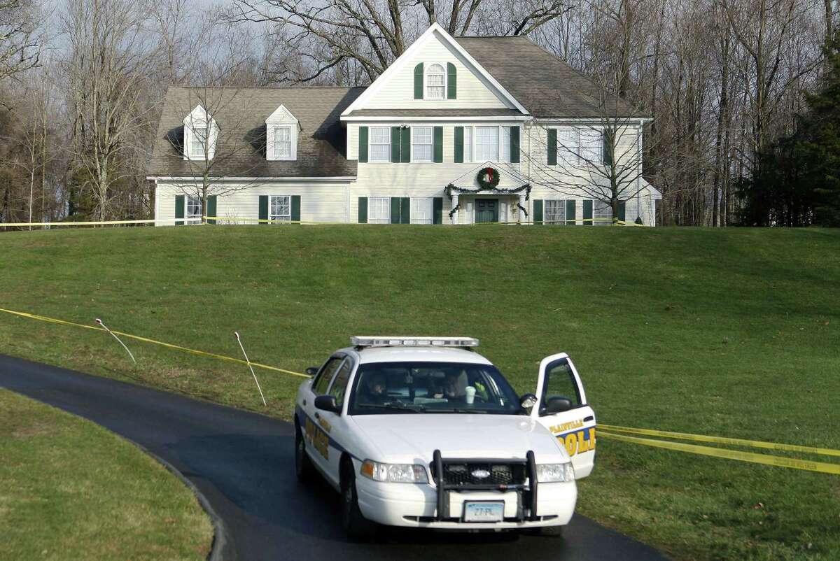 FILE - In this Dec. 18, 2012 file photo a police cruiser sits in the driveway of the home of Nancy Lanza, in Newtown, Conn. The Colonial-style home where Newtown school shooter Adam Lanza lived with his mother has been transferred to the town in a deal with a bank. Nancy Lanza was killed there by her son before he forced his way into Sandy Hook Elementary School, Dec. 14, 2012, in Newtown, where he killed 20 first-graders and six educators. The future use of the house and property will be decided later. (AP Photo/Jason DeCrow, File)
