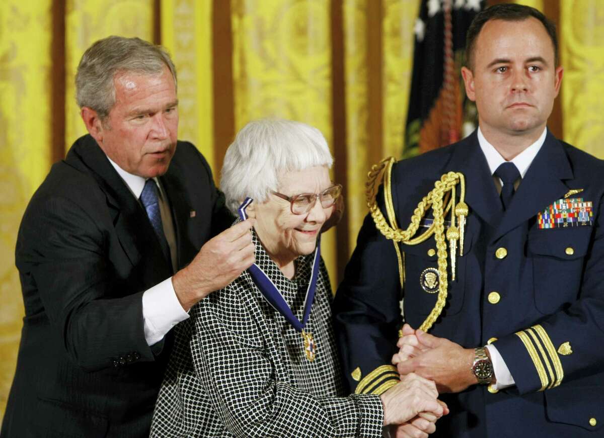 In this Nov. 5, 2007, file photo, President Bush, left, presents the Presidential Medal of Freedom to author Harper Lee, center, during a ceremony in the East Room of the White House in Washington. Lee, the elusive author of best-seller “To Kill a Mockingbird,” died Friday, Feb. 19, 2016, according to her publisher, Harper Collins. She was 89.