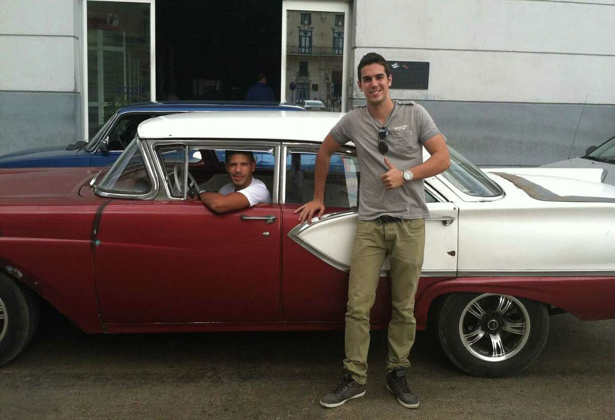 Mario Otero in front of a classic American car driven by his friend Camilo Rodriguez in Havana, Cuba. Otero, 25, works as a waiter in one of Havana’s best restaurants, has a tourism degree, moonlights as a private tour guide with a goal of someday opening his own tourism agency, and sees increased tourism in Cuba as a key to achieving his dreams.