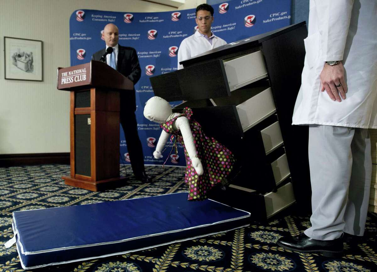 Consumer Product Safety Commission (CPSC) Chairman Elliot Kaye, left, watches a demonstration of how an Ikea dresser can tip and fall on a child during a news conference at the National Press Club in Washington on June 28, 2016. Ikea is recalling 29 million chests and dressers after six children were killed when the furniture toppled over and fell on them.