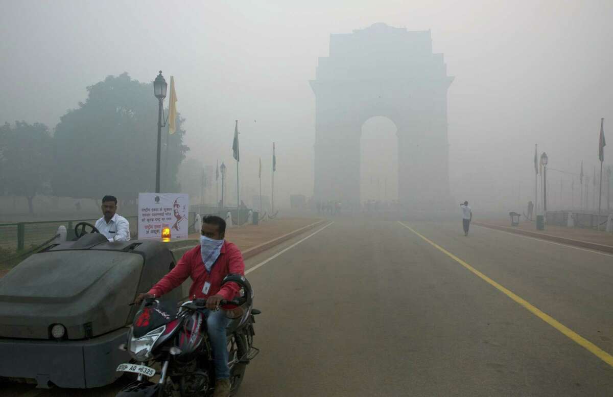 A man covers his face with a scarf as he rides in front of the landmark India Gate, enveloped by smoke and smog, on the morning following Diwali festival in New Delhi, India on Oct. 31, 2016. As Indians wake Monday to smoke-filled skies from a weekend of festival fireworks for the Hindu holiday of Diwali, New Delhi’s worst season for air pollution begins, with dire consequences. A new report from UNICEF says about a third of the 2 billion children in the world who are breathing toxic air live in northern India and neighboring countries, risking serious health effects including damage to their lungs, brains and other organs.