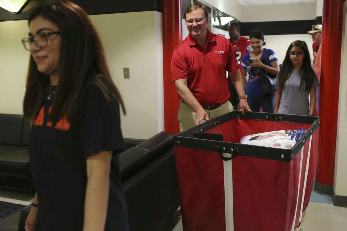 University of the Incarnate Word President Thomas Evans helps incoming freshman Savannah Hernandez, 18, left, of Corpus Christi, move into the Agnese/Sosa Residence Hall, Thursday, August 24, 2017. Evans took over the position from Louis Agnese who led the university for three decades but left under a swirl of controversy.