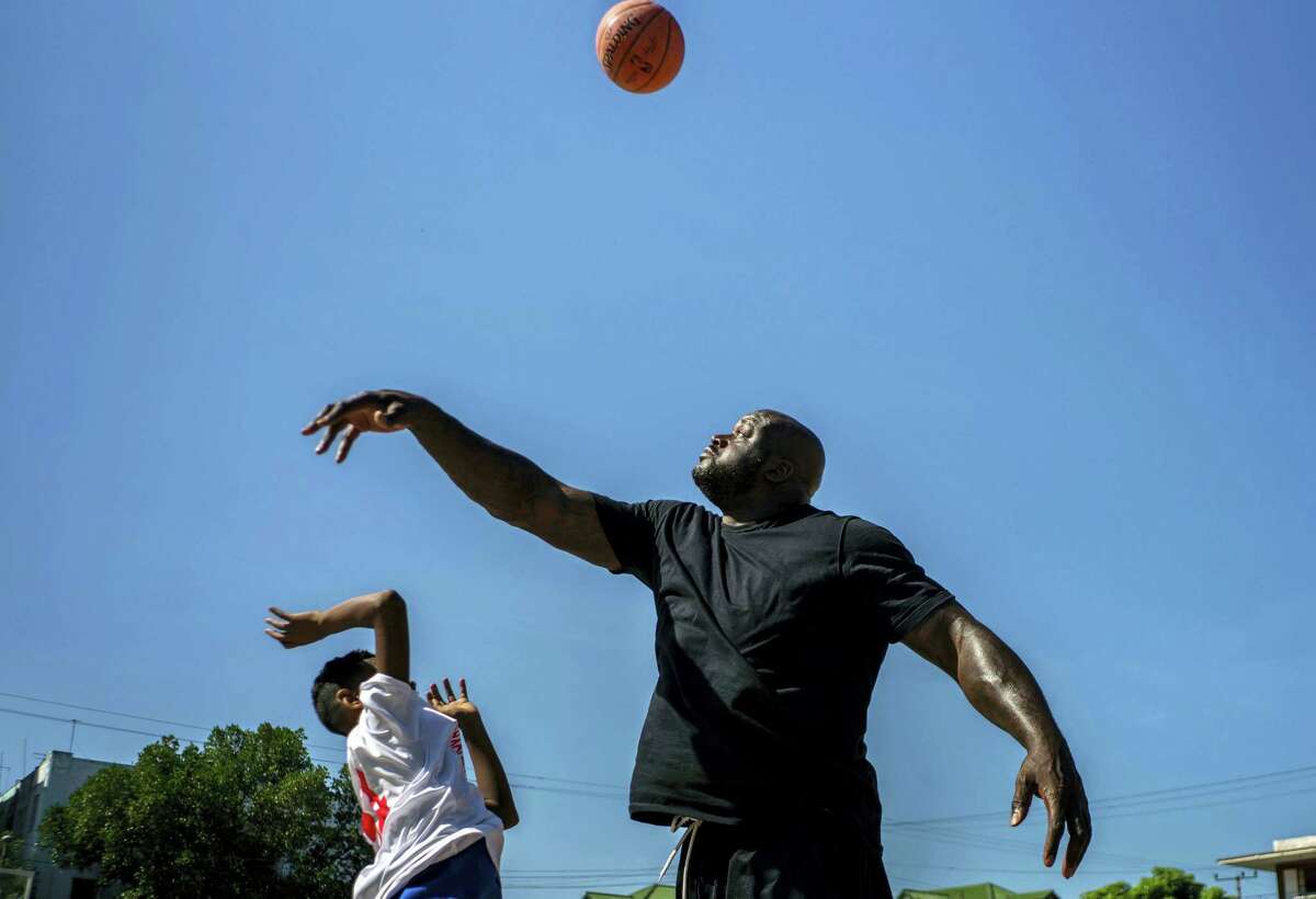 Shaquille O’Neal plays with a youngster during a clinic in Havana on Sunday.