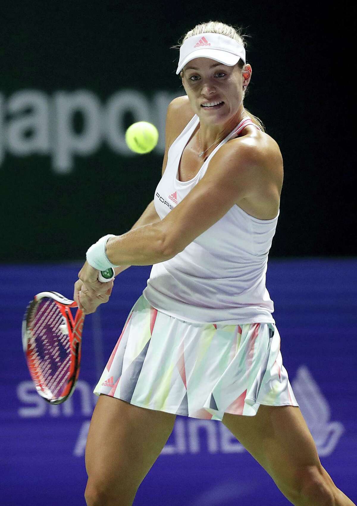 Angelique Kerber of Germany makes a backhand return to Dominika Cibulkova of Slovakia during their women’s final match at the WTA tennis tournament in Singapore on Oct. 30, 2016.
