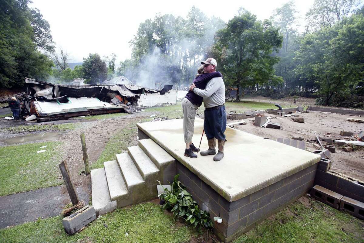Jimmy Scott gets a hug from Anna May Watson, left, as they clean up from severe flooding in White Sulphur Springs, W. Va. on June 24, 2016.