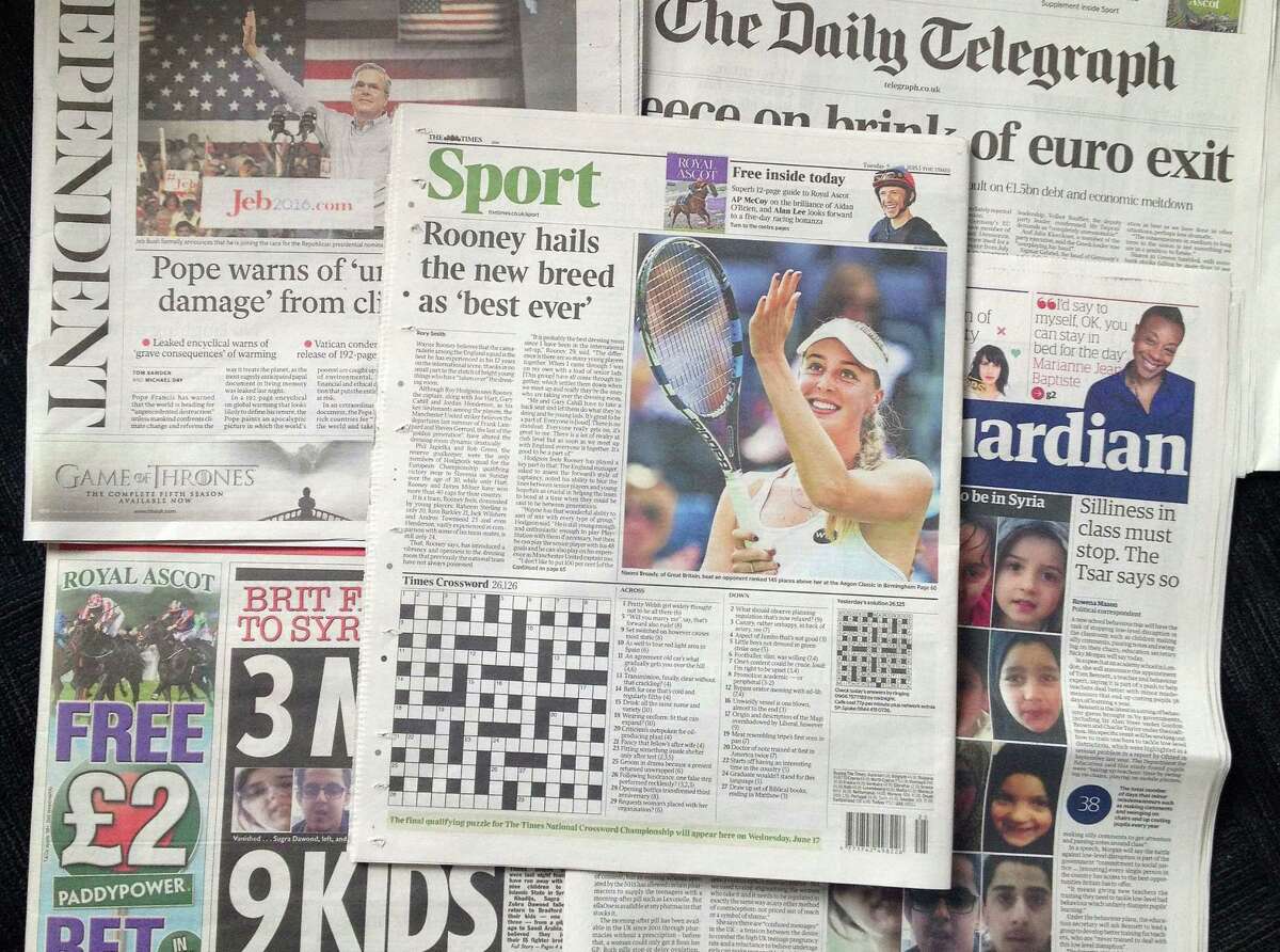 A combo taken on Wednesday June 17, 2015 showing some of the British national newspapers of Tuesday June 16 and featuring at centre the back page of The Times showing it's daily crossword puzzle. A crossword-loving British lawyer hid a marriage proposal in Tuesday's edition of The Times newspaper's daily puzzle. Matthew Dick thought of the cryptic way of popping the question to girlfriend Delyth Hughes, and persuaded the newspaper to agree. (AP Photo/Tony Hicks)