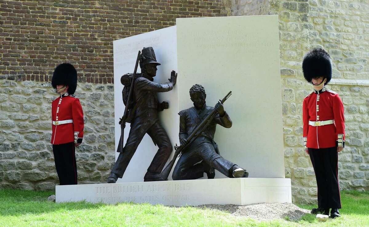Guards stand on either side of a newly unveiled memorial during the ceremonial opening of Hougoumont Farm in Braine-l'Alleud, near Waterloo, Belgium on Wednesday, June 17, 2015. Hougoumont Farm played a critical role in the outcome of the Battle of Waterloo, and the newly restored farm will open to the general public on June 18, 2015. (AP Photo/Emmanuel Dunand/Pool Photo via AP)