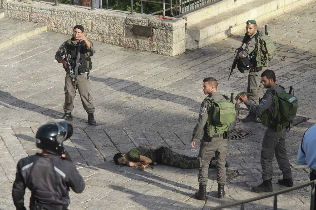 Israeli police stand around a Palestinian shot after he allegedly tried to stab a person at Damascus Gate of the Jerusalem’s Old City, Wednesday, Oct. 14, 2015, Israeli police said.
