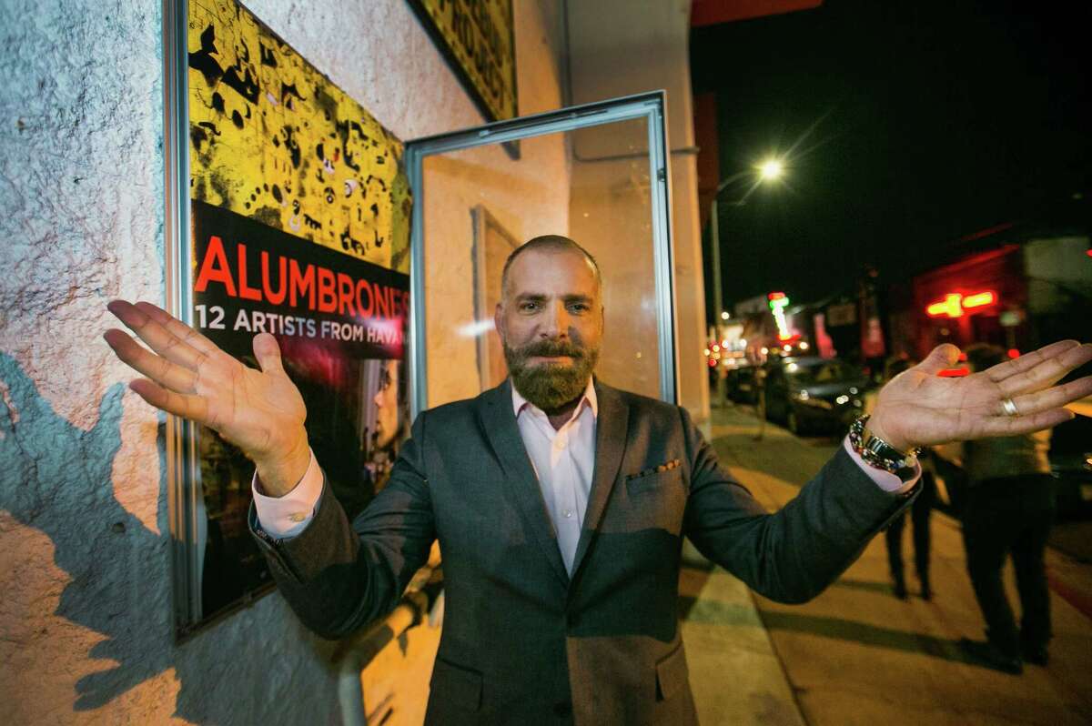 Cuban producer Fermin Rojas poses with the poster of his film, “Alumbrones,” Spanish for “illuminations,” before its opening at the Arena Cinema Hollywood in Los Angeles. When Rojas wanted to make a documentary profiling 12 Cuban artists living in and around Havana, he used a Canadian production company and a cultural license to film on the island. Rojas is already at work on a second documentary, this one about a gay men’s choir in Havana.