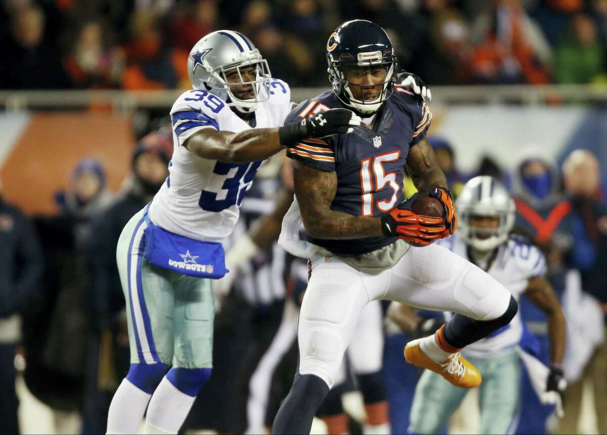 Chicago Bears wide receiver Brandon Marshall (15) makes a catch under pressure from Dallas Cowboys cornerback Brandon Carr (39) during the first half of an NFL football game on Dec. 9, 2013 in Chicago.
