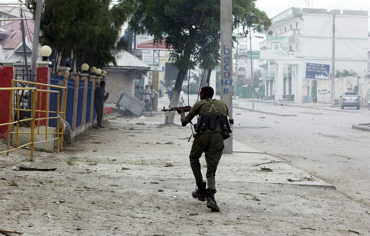 A Somali soldier takes position during an attack on Nasahablod Hotel, in Mogadishu, Somalia, Saturday, a June 25, 2016 . A Somali police officer says a suicide car bomber detonated an explosives-laden vehicle at the gate of a hotel in Mogadishu followed by gunmen who were fighting their way into the hotel.
