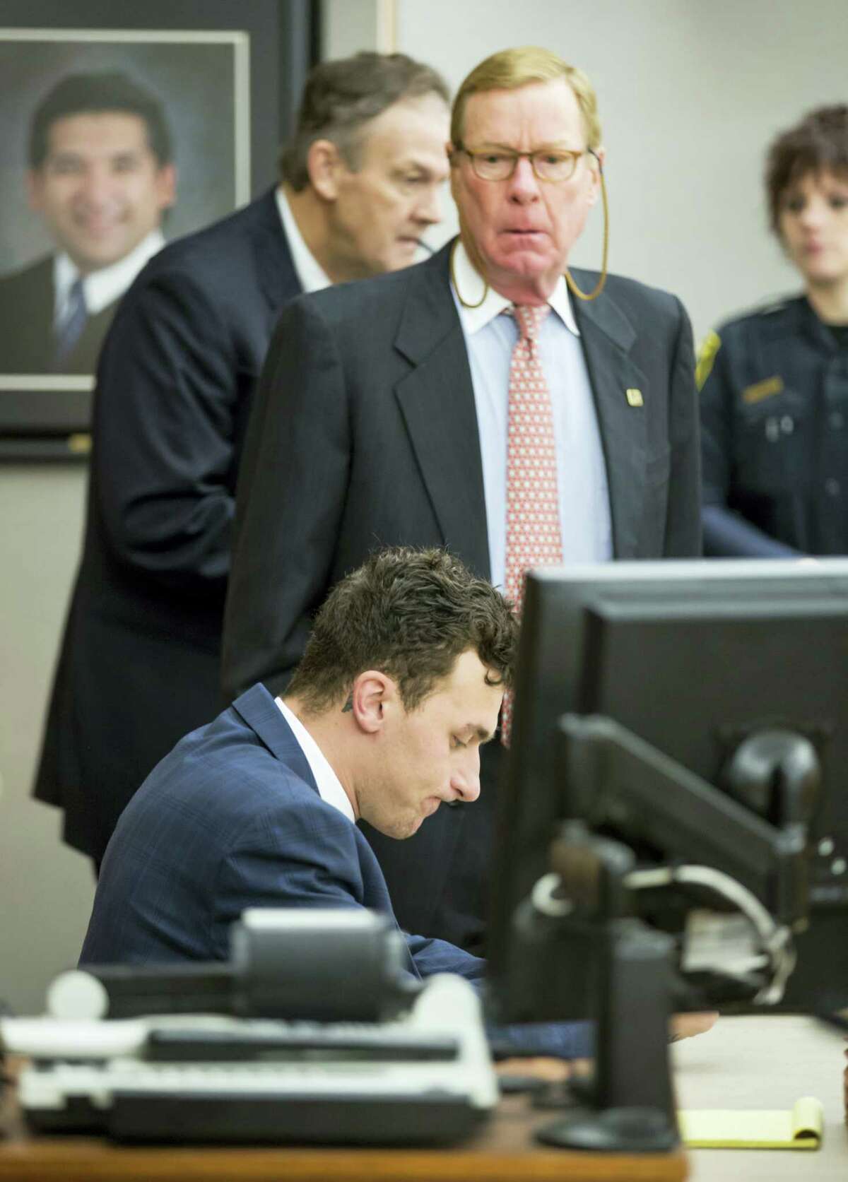 Former Cleveland Browns quarterback Johnny Manziel sits at the defense table as his attorney Bob Hinton, center, looks on during a hearing, in Dallas.