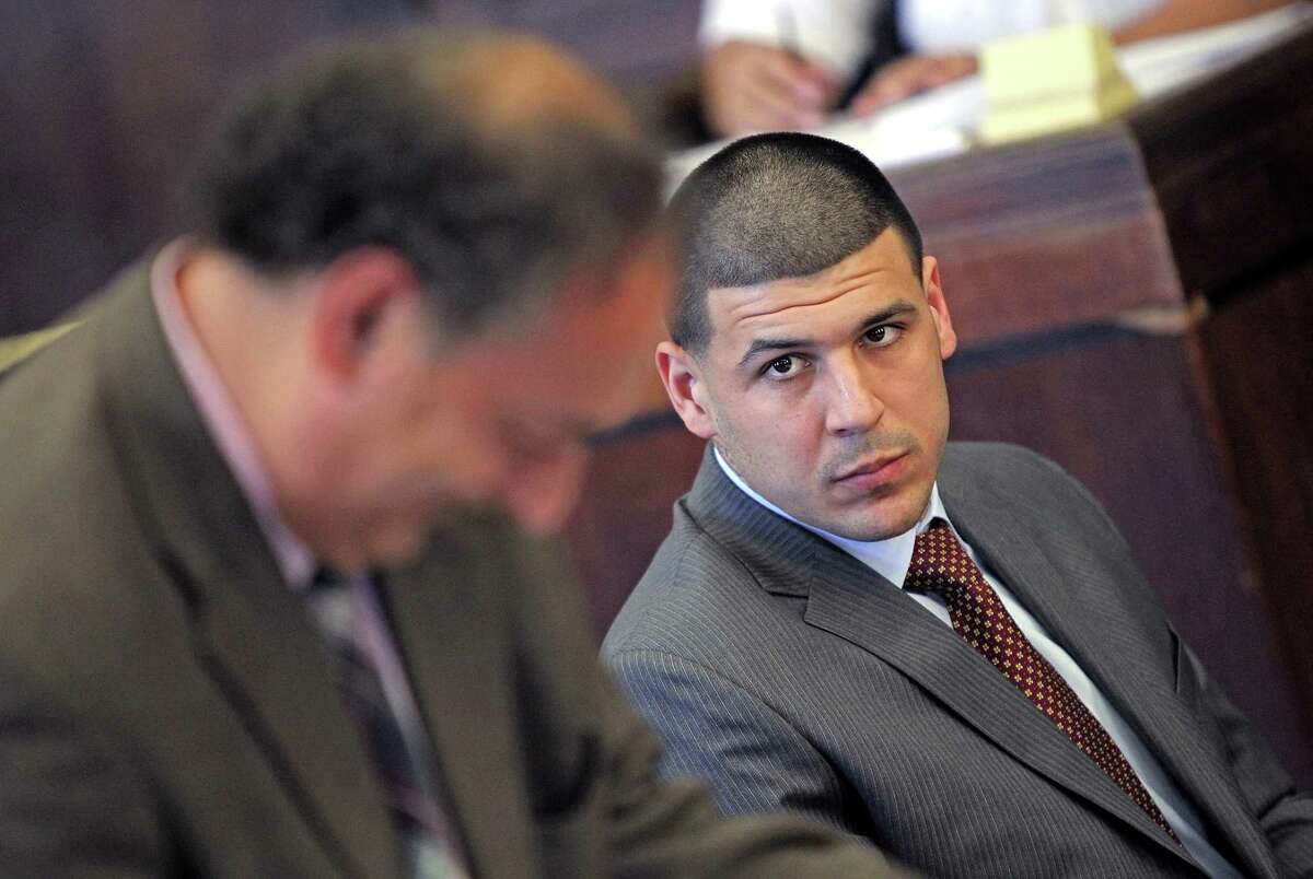 Former New England Patriots NFL football player Aaron Hernandez, right, looks over at his defense attorney James Sultan during his court hearing at Suffolk Superior Court in Boston, Tuesday, Oct. 6, 2015. Lawyers for Hernandez have asked a judge to throw out a search warrant that led police to seize a vehicle that prosecutors say Hernandez was driving when he fatally shot two Boston men in 2012.