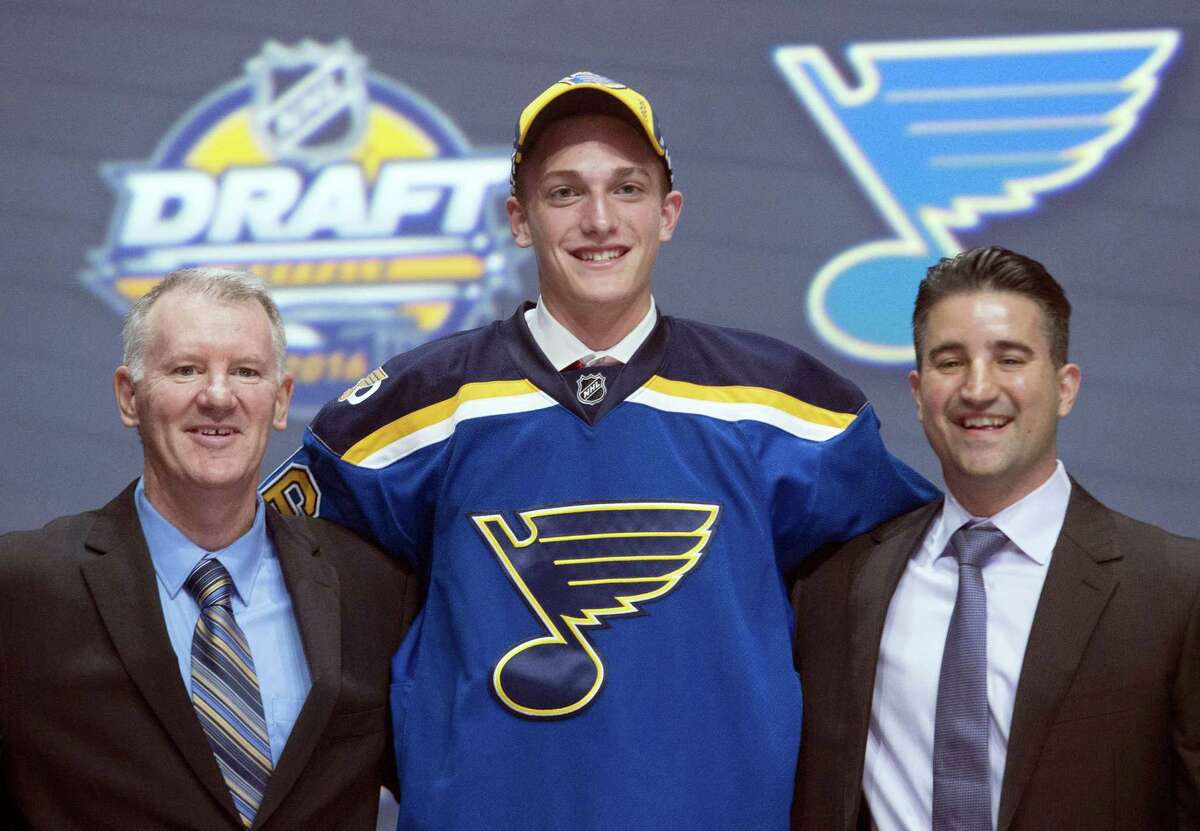 Tage Thompson, center, stands with members of the St. Louis Blues management team at the NHL draft on Friday.