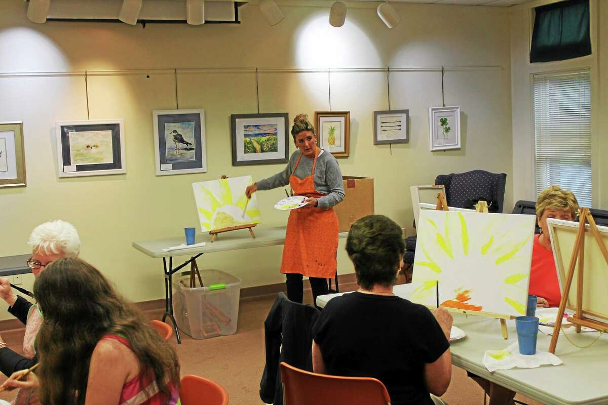 Artist Ashley Ludovico gives instructions to students Monday night for Paint Night at the Harwinton Library