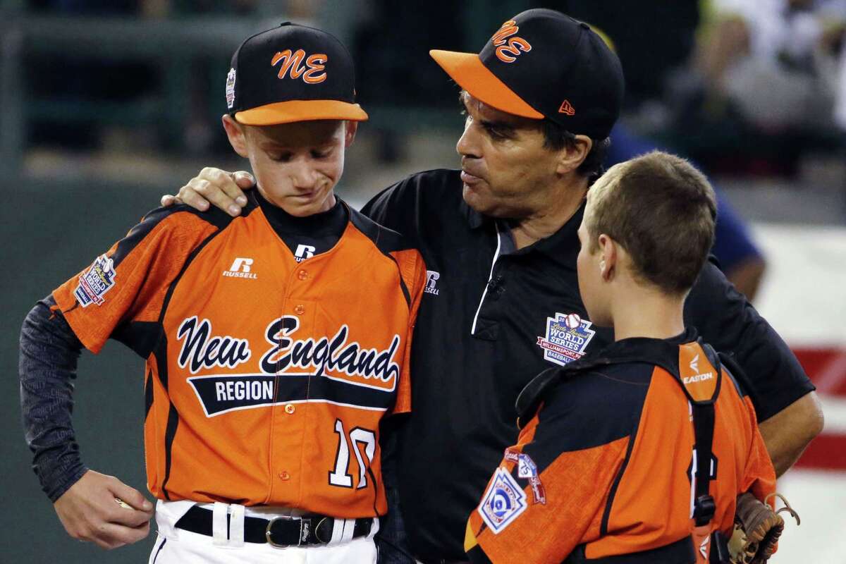 In this Aug. 18, 2014 file photo, Cumberland manager David Belisle talks with pitcher CJ Davock, left, and catcher Trey Bourque during the fifth inning of an elimination game against Chicago at the Little League World Series in South Williamsport, Pa. Chicago won 8-7. It was announced Wednesday that the Chicago team was stripped of its national title for using players from outside league boundaries. Belisle said Cumberland got beat by cheaters and the adults who orchestrated the scheme should be ashamed.