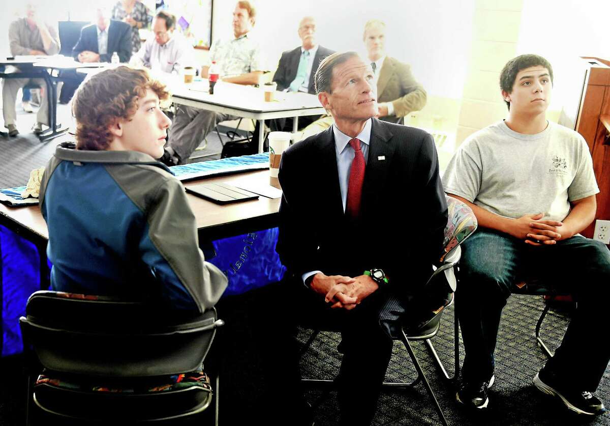 U.S. Sen. Richard Blumenthal, D-Conn., center, with Sound School Regional Vocational Aquaculture Center seniors Zachary Pope of Hamden, left, and Marcus Ramirez of North Haven, right, watch with other Sound School students, teachers, environmental groups and guests, a Connecticut Fund for the Environment and Save The Sound powerpoint presentation on the environmental and ecological significance of Plum Island during a public forum Tuesday.