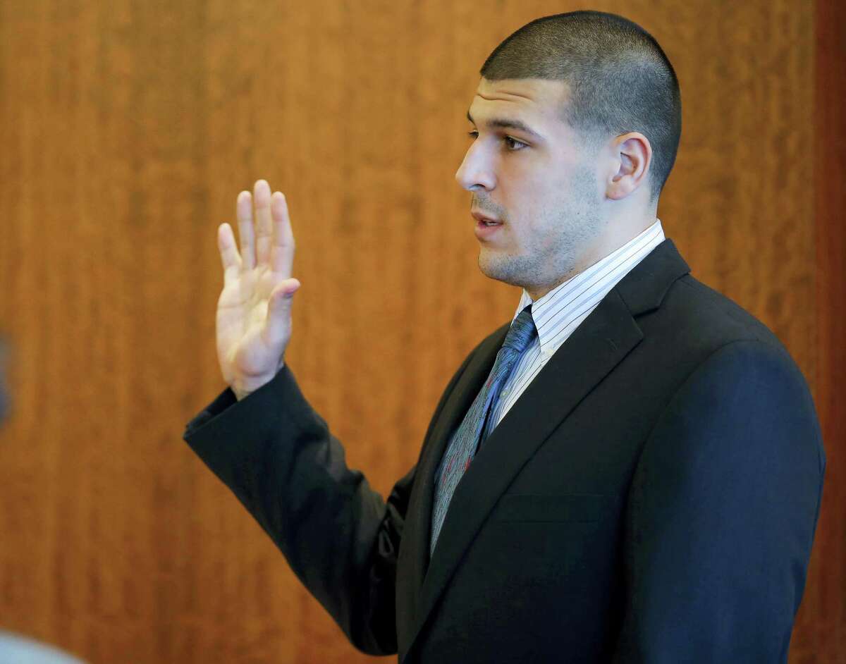 Former New England Patriots NFL football player Aaron Hernandez takes an oath during a pretrial court hearing in Fall River, Mass. on Wednesday, Oct. 9, 2013. Hernandez was indicted in August in the killing of 27-year-old Odin Lloyd, a semi-professional football player from Boston who was dating the sister of Hernandez’s girlfriend. He has pleaded not guilty.