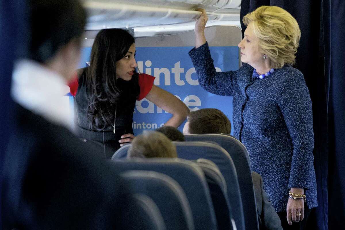 Democratic presidential candidate Hillary Clinton speaks with senior aide Huma Abedin, left, aboard her campaign plane at Westchester County Airport in White Plains, N.Y., Friday, Oct. 28, 2016, before traveling to Iowa for rallies.