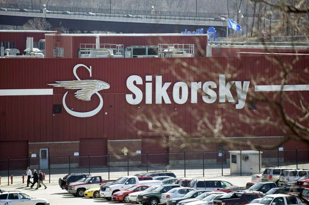 Workers walk outside of Sikorsky Aircraft, in Stratford, Conn.