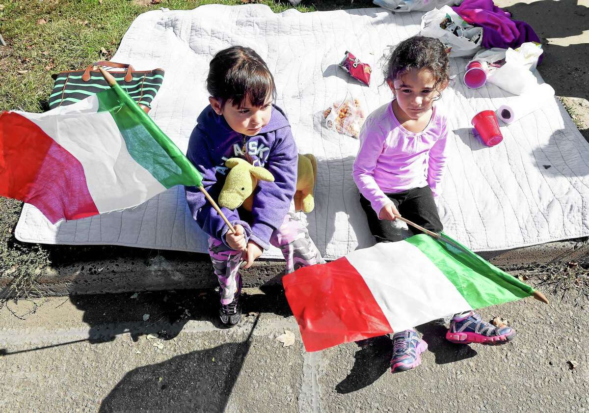 Gianna Cicarella (left), 5, and Delaney Shepard, 5, of East Haven watch the Greater New Haven Columbus Day Parade as it passes on Hemingway Ave. in East Haven on 10/11/2015.