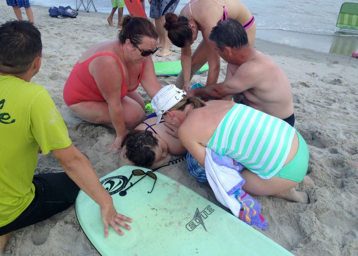 People assist a teenage girl at the scene of a shark attack in Oak Island, N.C. on June 14, 2015. Mayor Betty Wallace of Oak Island, a seaside town bordered to the south by the Atlantic Ocean, said that hours after the teenage girl suffered severe injuries in a shark attack Sunday a teenage boy was also severely injured.