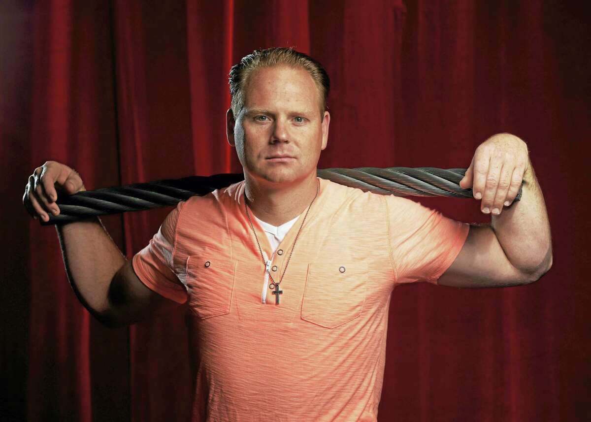Nik Wallenda poses for a photograph with a piece of the high wire he used to walk over Niagara Falls.