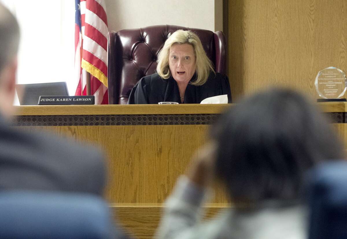 Lake County Juvenile Court Judge Karen Lawson, back, tells an 11-year-old girl her rights on Monday, Feb. 9, 2015 in Painesville, Ohio. Police say the 11-year-old girl has been charged with murder in the beating death of a 2-month-old who was staying overnight with the girl and her mother to give the baby's mom a break. A juvenile judge entered a not guilty plea for the girl on Monday. She remains in the Lake County juvenile detention center and will receive a competency evaluation. (AP Photo/The News Herald, Duncan Scott)