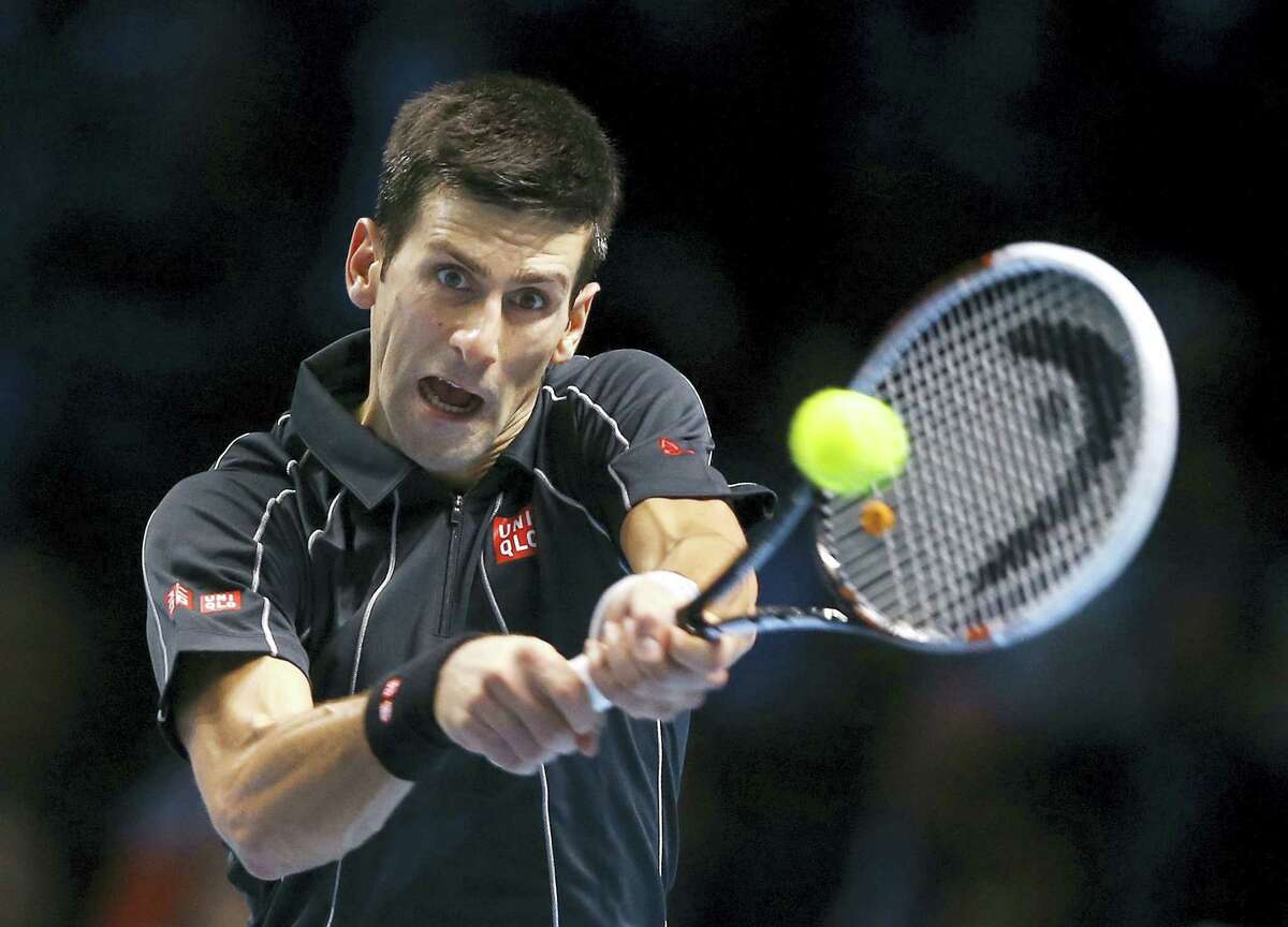 Novak Djokovic of Serbia plays a return to Roger Federer of Switzerland during their ATP World Tour Finals tennis match at the O2 Arena in London on Nov. 5, 2013.