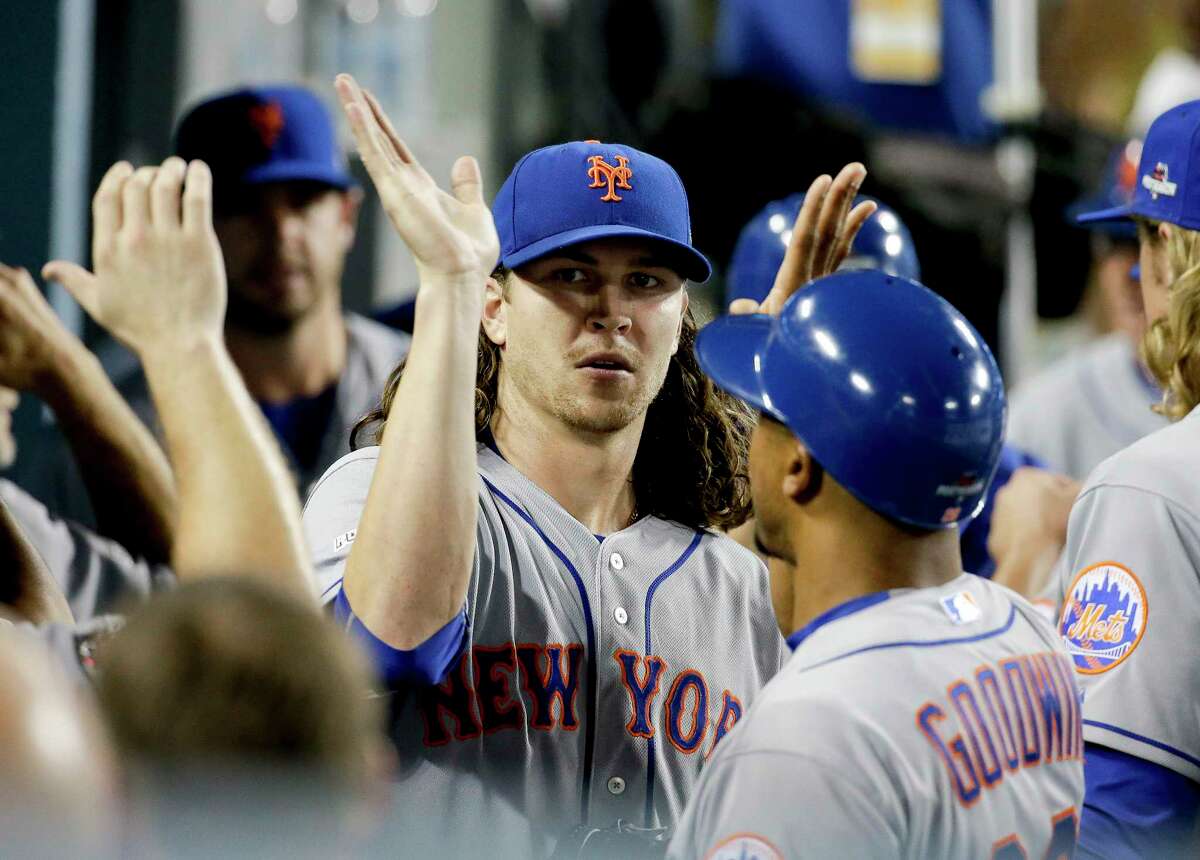 Mets starting pitcher Jacob deGrom celebrates in the dugout the end of the seventh inning Friday night.