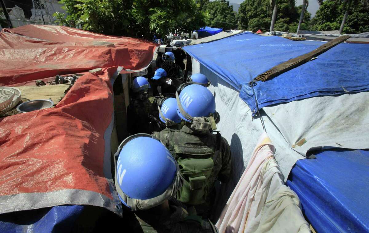 FILE - In this Tuesday, March 30, 2010 file photo, United Nations peacekeepers patrol an earthquake survivors makeshift camp in Port-au-Prince. In 2015, troubled by peacekeepers' sexual relationships with the people they are meant to protect, the UN has quietly started helping with DNA collection to prove paternity claims for so-called "peacekeeper babies." (AP Photo/Jorge Saenz)
