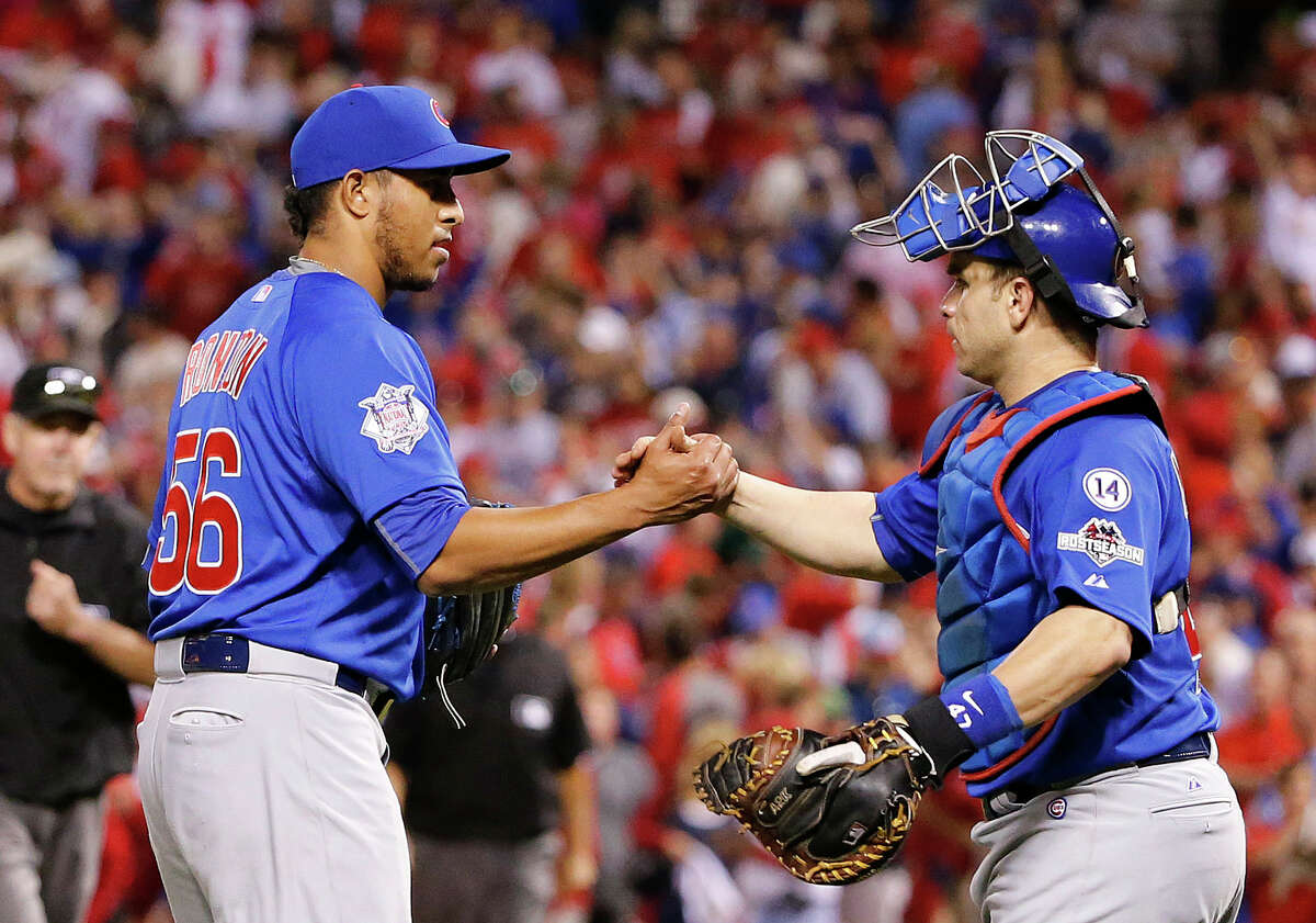 The Cubs’ Hector Rondon, left, is congratulated by catcher Miguel Montero after the Cubs defeated the Cardinals in Game 2 of the NLDS on Saturday.