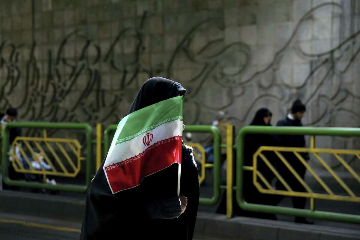 An Iranian woman holds the national flag during a rally commemorating the 37th anniversary of the Islamic revolution, in Tehran, Iran, Thursday, Feb. 11, 2016. The revolution, on Feb. 11, 1979, saw followers of Ayatollah Khomeini oust the U.S.-backed Shah Mohammad Reza Pahlavi and is celebrated annually. However, Iranians are no longer allowed to celebrate Valentine’s Day, which is considered a “decadent Western” holiday.