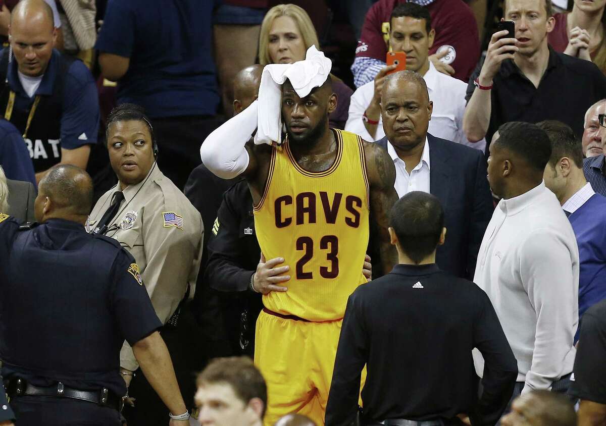 The Cavaliers’ LeBron James holds a towel to his head after being knocked into the fans during Game 4 of the NBA Finals against the Golden State Warriors. The Warriors won 103-82.