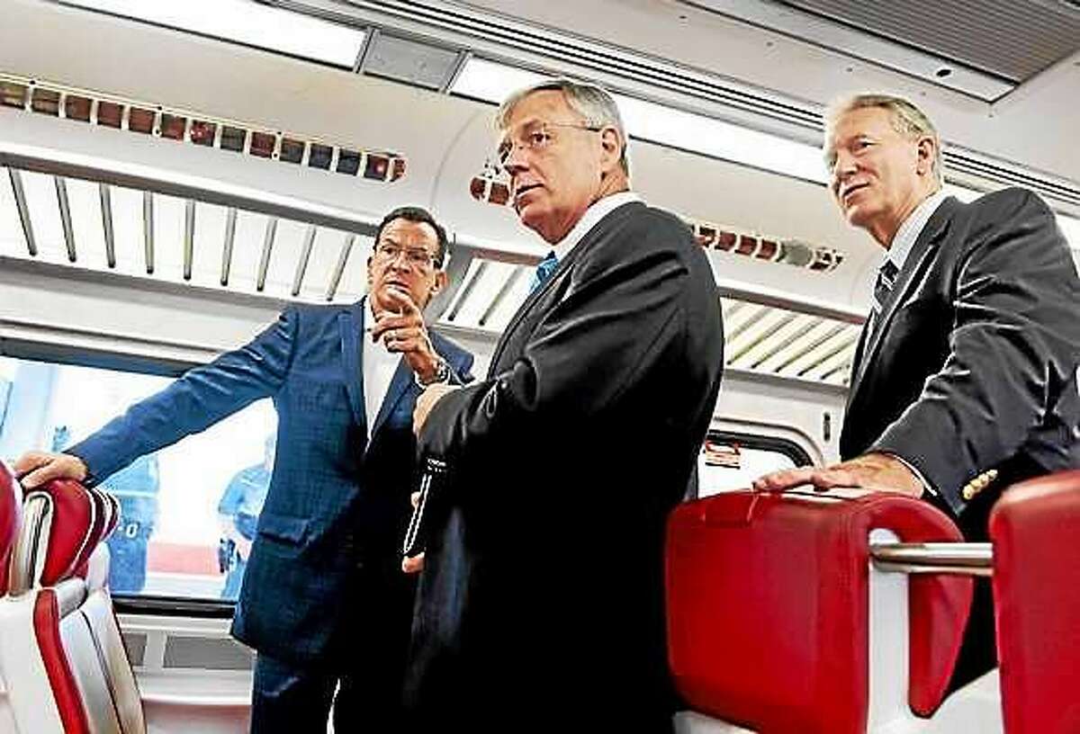 PETER HVIZDAK — NEW HAVEN REGISTER FILE PHOTO Connecticut Gov. Dannel P. Malloy, left, Connecticut DOT Commissioner James Redeker, center, and John Hartwell, vice chair of the CT Commuter Rail Council, right, tour an M-8 commuter rail car after a press conference at Union Station in New Haven on July 27, 2015.