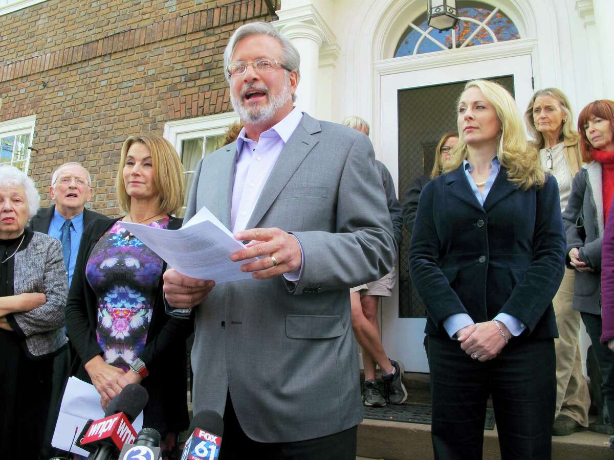 Connecticut state House candidate Dr. William Petit, flanked by House Minority Leader Themis Klarides, R-Derby, left, and his wife, Christine, right, speaks to the news media Wednesday outside his home in Plainville about a political advertisement linking him to Donald Trump and attacks on women and families. Petit’s first wife and two daughters were killed in the Cheshire 2007 home invasion.