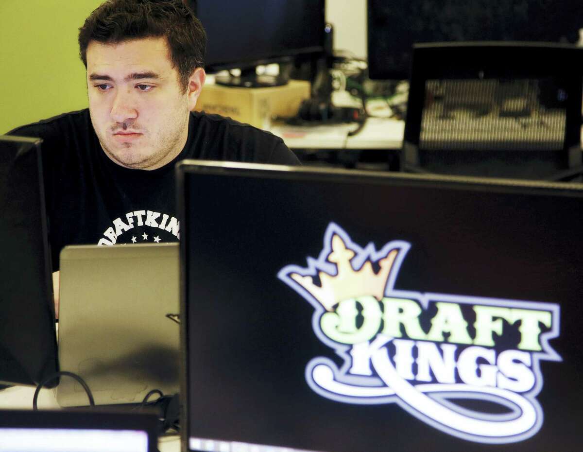 In this Sept. 9, 2015 photo, Len Don Diego, marketing manager for content at the DraftKings daily fantasy sports company, works at his station at the company’s offices in Boston.