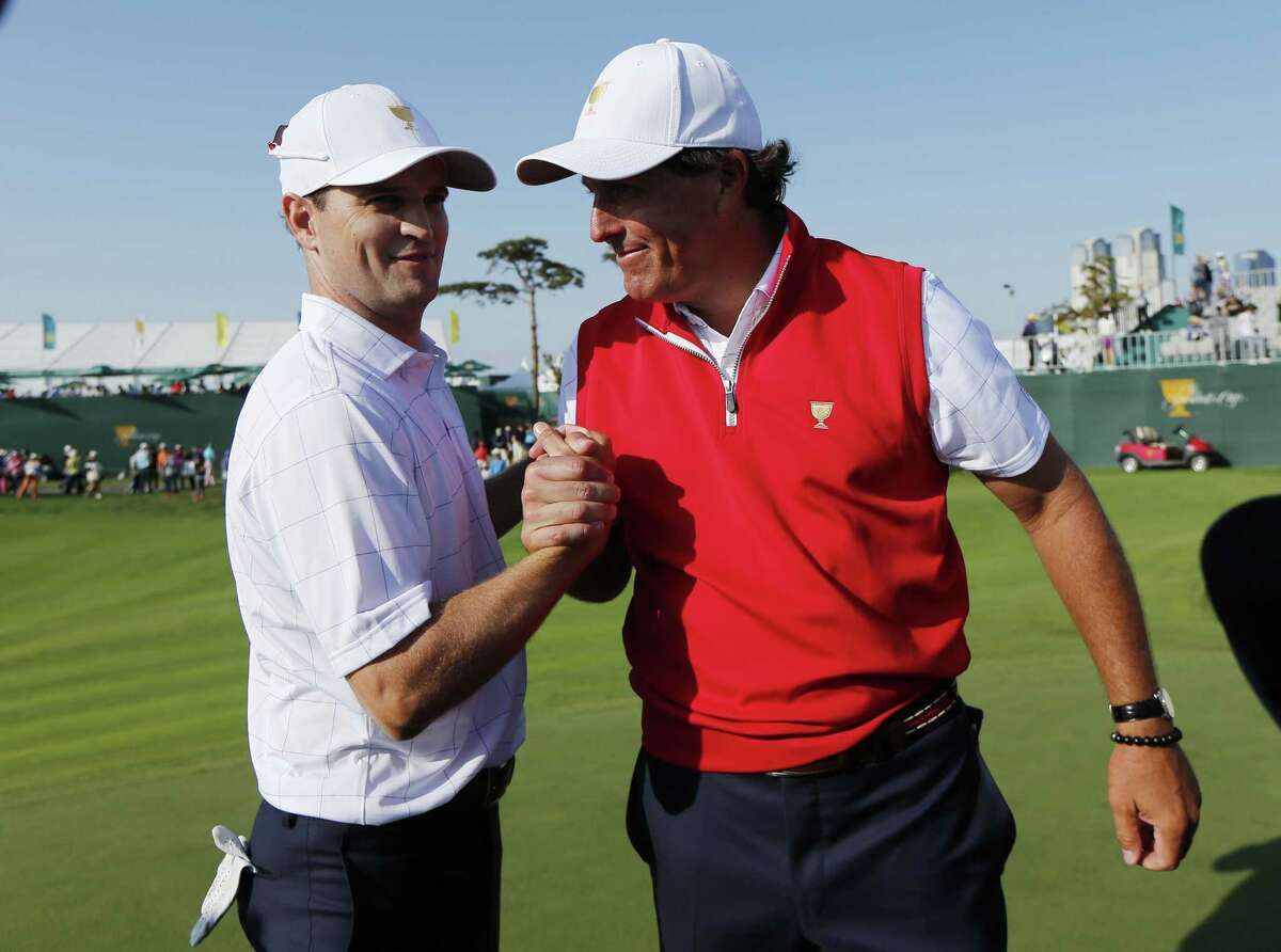 The United States’ Phil Mickelson, right, shakes hands with partner Zach Johnson after they won their their foursome match Thursday at the Presidents Cup at the Jack Nicklaus Golf Club Korea in Incheon, South Korea.