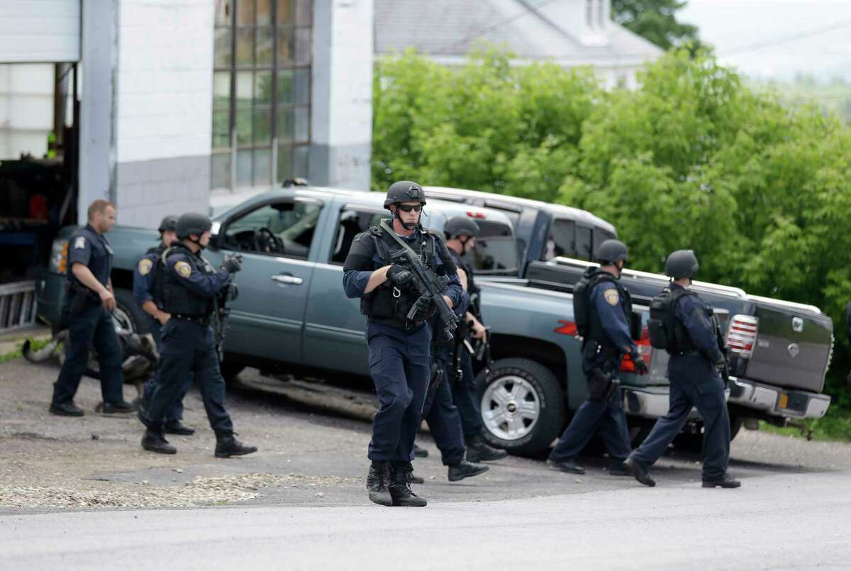 Law enforcement officials walk the streets near the prison in Dannemora, N.Y. on June 10, 2015. Police were resuming house-to-house searches near the maximum-security prison in northern New York where two killers escaped using power tools, authorities said Wednesday as they renewed their plea for help from the public.