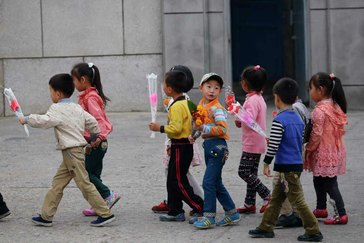 Children walk with decorative flowers for the upcoming anniversary celebrations in Pyongyang, North Korea, Thursday, Oct. 8, 2015. The country is in high gear with preparations for the 70th anniversary of the founding of the North Korea Workers’ Party on Oct. 10, 2015.