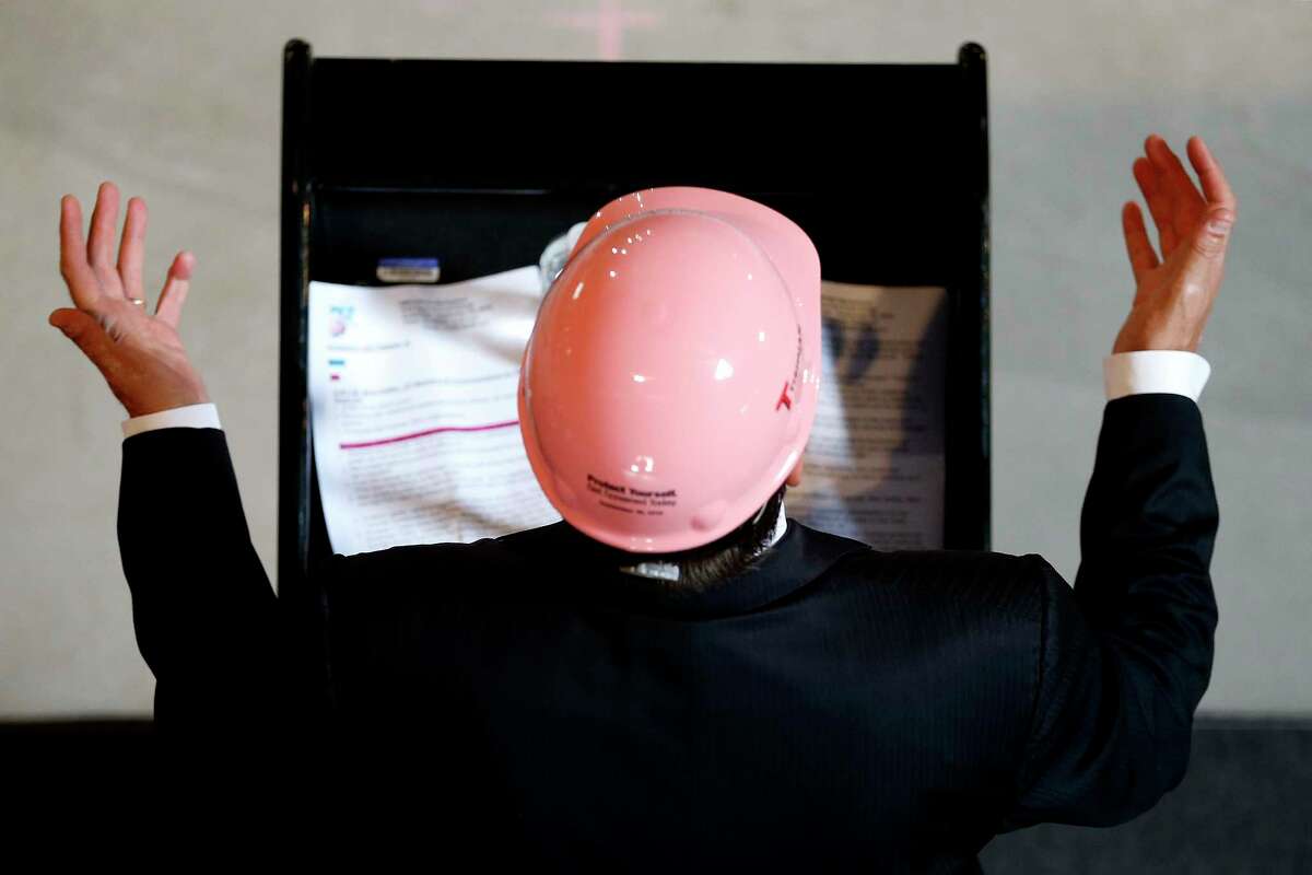 Supporters of breast cancer awareness wear pink hardhats while forming a ribbon at a construction site, Wednesday, Sept. 30, 2015, in Fort Lee, N.J. EMCOR, which provides mechanical and electrical construction services, presented a $50,000 donation to the John Theurer Cancer Center Breast Oncology Division at Hackensack University Medical Center during the event.