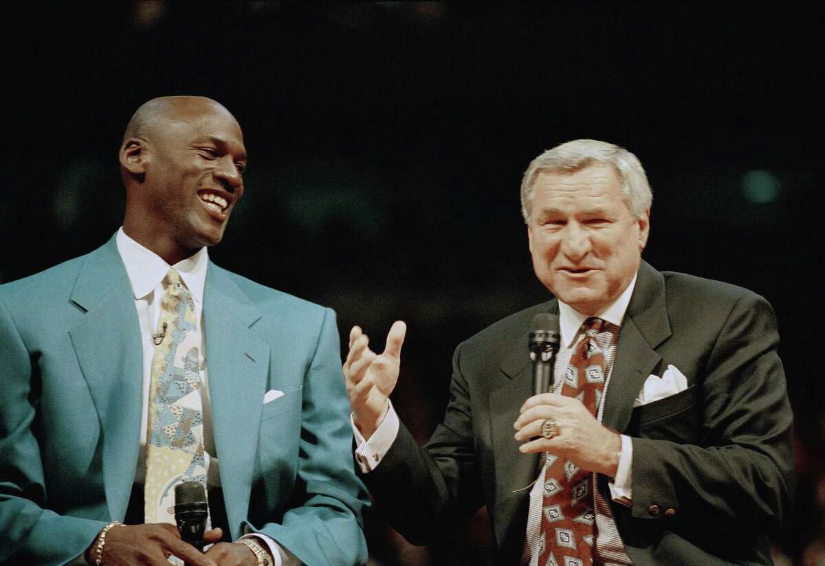Former Chicago Bulls great Michael Jordan, left, shares a moment with Dean Smith, his former coach at North Carolina, during ceremonies honoring Jordan at Chicago’s United Center. Smith, the North Carolina basketball coaching great who won two national championships, died “peacefully” at his home Saturday night the school said in a statement Sunday from Smith’s family. He was 83.