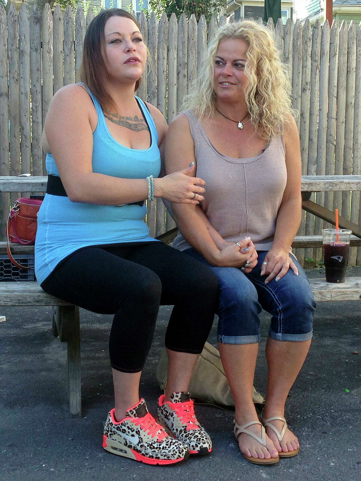 In this Sept. 18, 2015 photo, Kylee Moriarty, left, and her mother, Jackie Law, sit together outside the halfway house in Boston where Moriarty resided. This was their first meeting in person in more than a year. Moriarty is among more than 200 addicts taking advantage of a unique program offered by police in Gloucester, in which heroin addicts are fast-tracked into treatment rather than arrested.