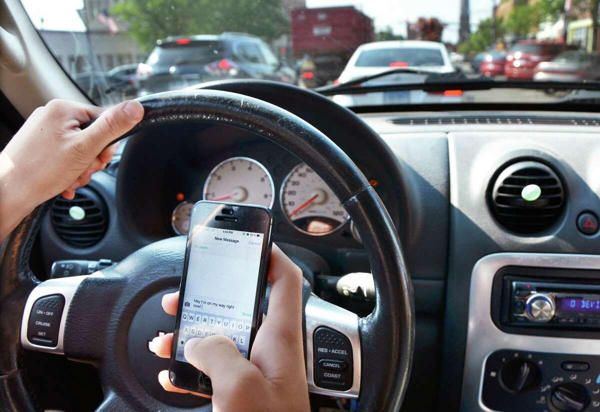 PHOTO ILLUSTRATION BY CATHERINE AVALONE — THE MIDDLETOWN PRESS Driving while texting.