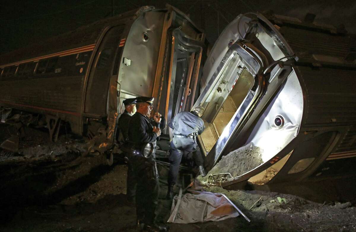 In this May 12, 2015 photo, emergency personnel work the scene of a train wreck in Philadelphia.