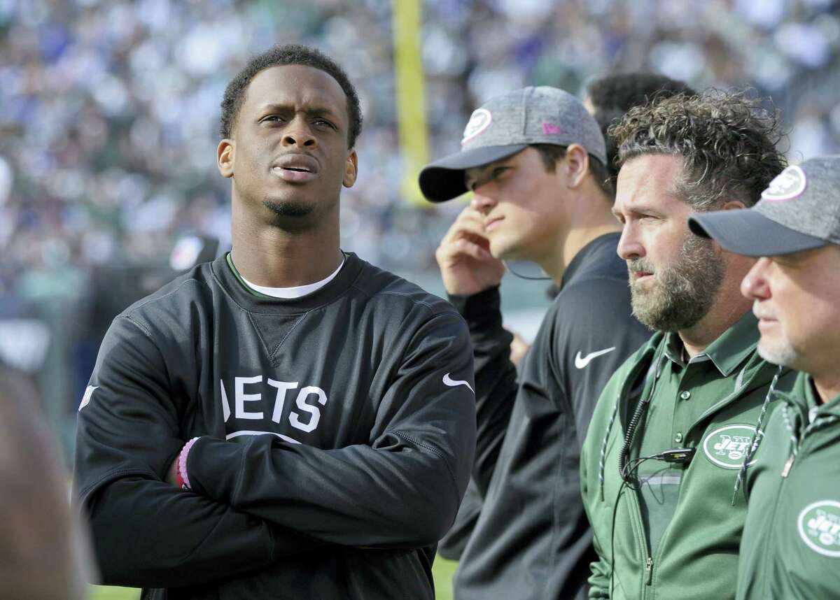 Jets quarterback Geno Smith, left, watches from the sidelines after leaving the game with a knee injury during the third quarter Sunday.