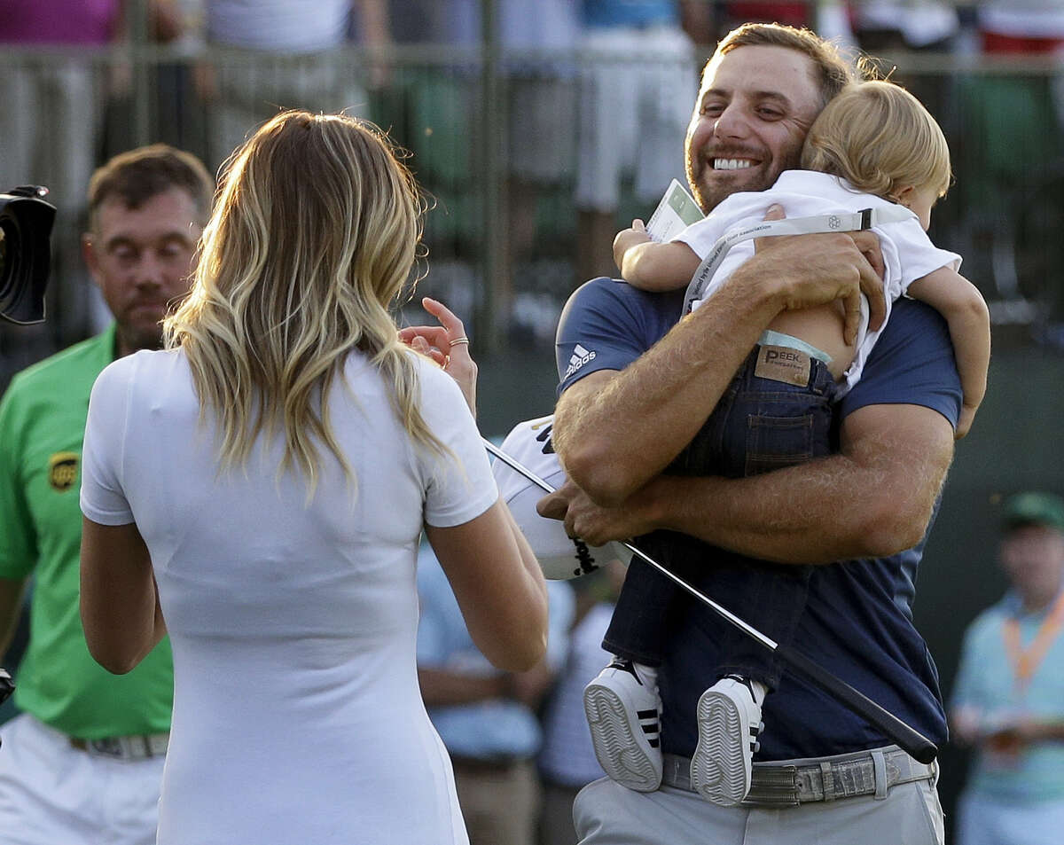 Dustin Johnson, right, greets his fiancé Paulina Gretzky as he holds their son Tatum Gretzky at the U.S. Open at Oakmont Country Club on Sunday.