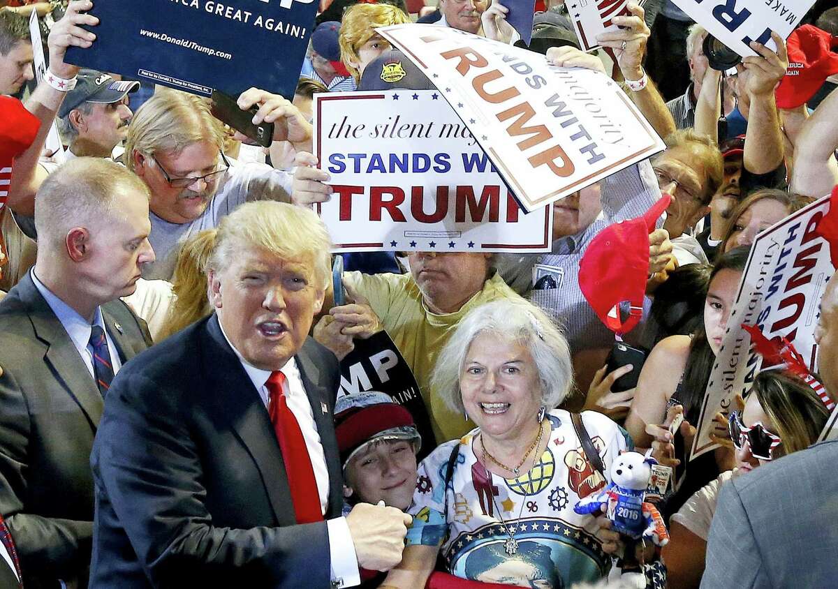Republican presidential candidate Donald Trump, left, shouts to Secret Service agents that supporter Diana Brest, right, had been waiting in line since 2 a.m. to see the candidate speak at a rally on June 18, 2016 in Phoenix.