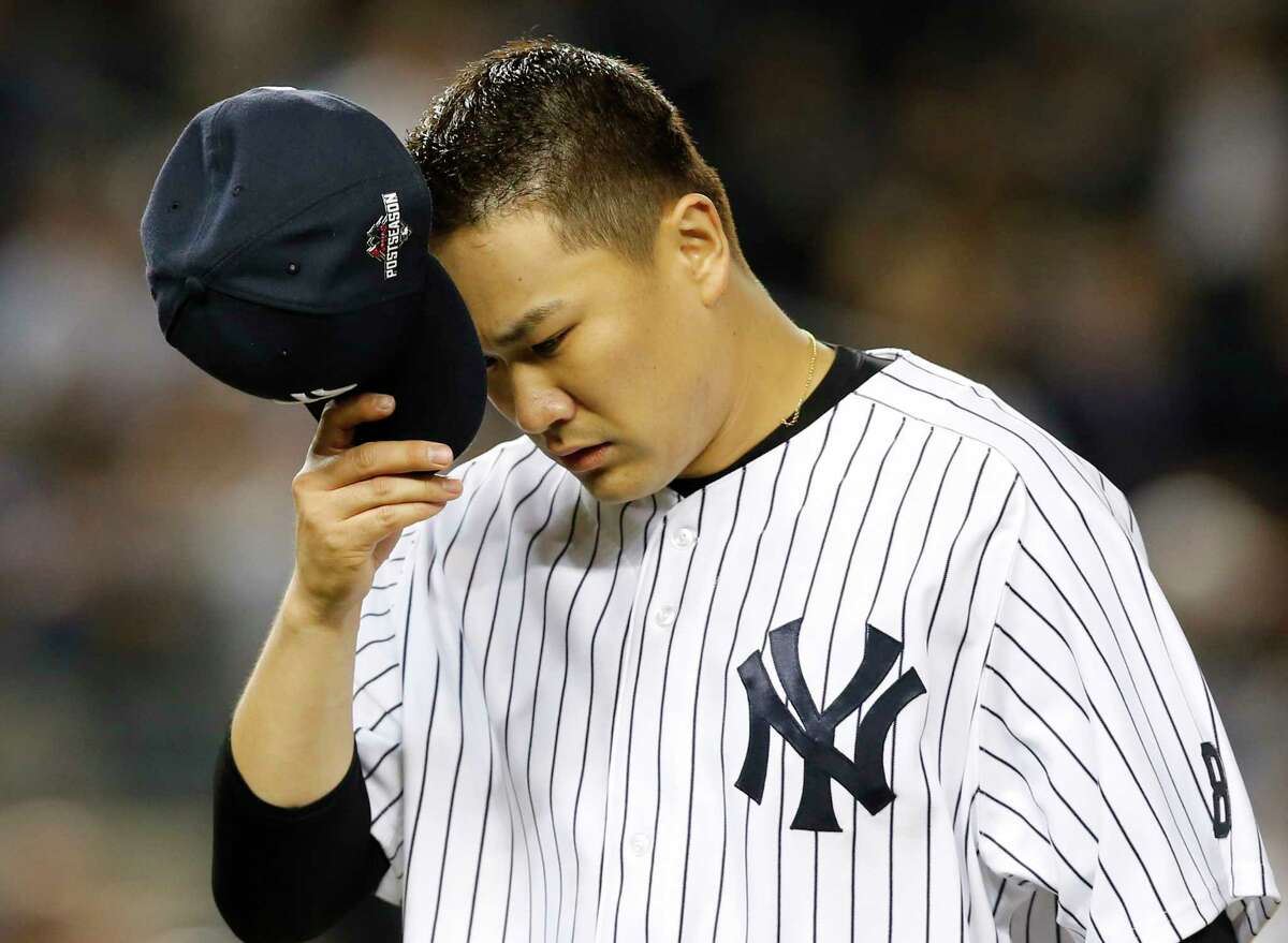 New York Yankees starting pitcher Masahiro Tanaka removes his cap as he leaves the mound in the fifth inning of the American League wild card baseball game against the Houston Astros at Yankee Stadium in New York, Tuesday, Oct. 6, 2015. (AP Photo/Kathy Willens)