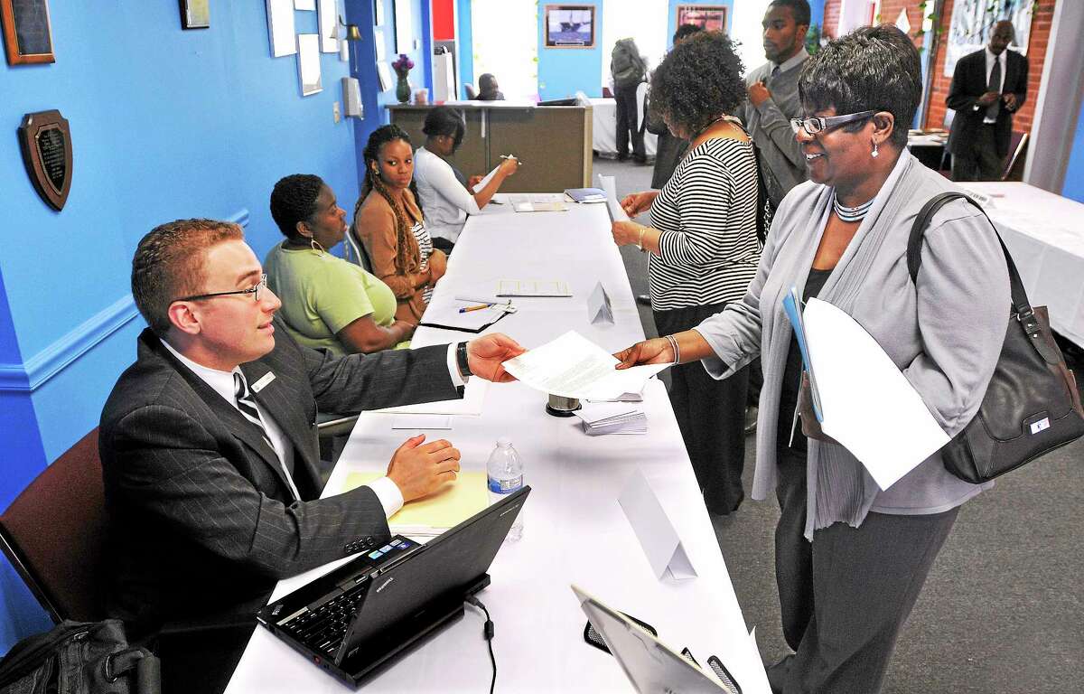 In this file photo, Madelyn Robinson of New Haven hands her resume off to Grant Faber, a human resources rep from Omni Hotel & Resorts, during the STRIVE Career Resource fair. Around 200 job seekers sought employment opportunities from 14 local employers at the event. (Peter Casolino — New Haven Register)